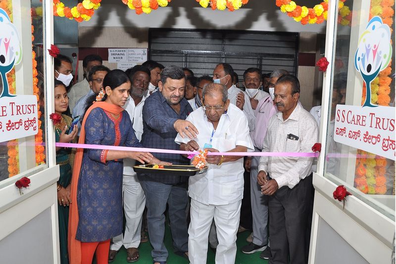 An elder cuts the ribbon to open the SS Care Trust free haemodialysis centre.