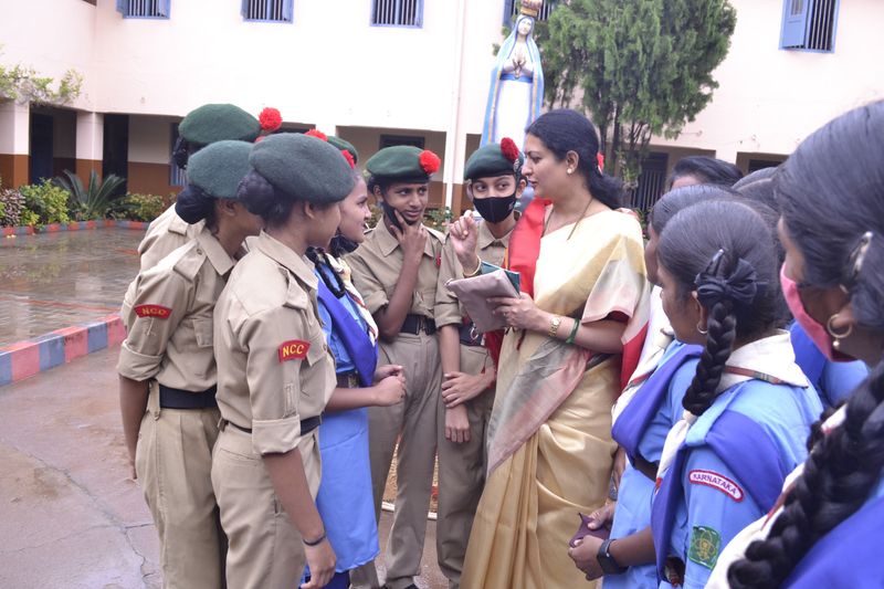A trust representative talks with NCC cadets and schoolgirls during an adolescent health session.