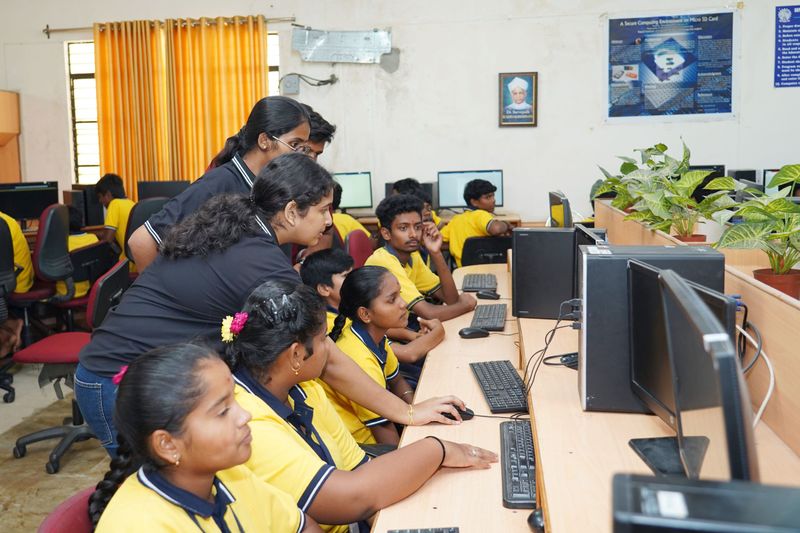 School students learn on desktop computers in a computer lab.