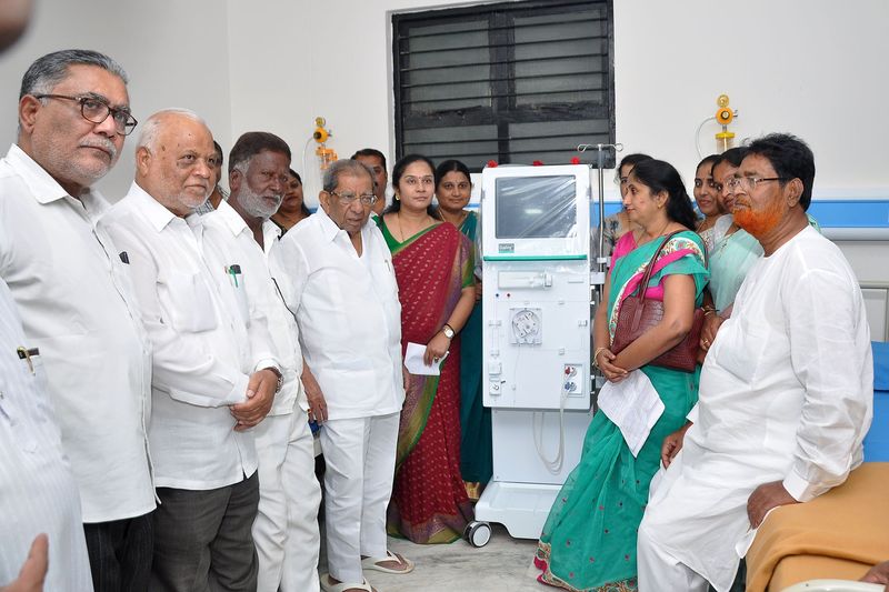 Trustees and guests gather around a new dialysis machine at its inauguration.
