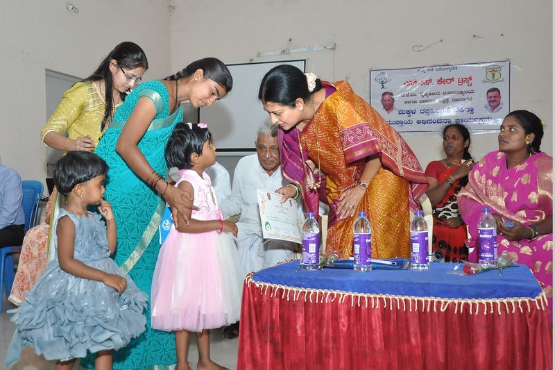A trust representative presents a certificate to a little girl.
