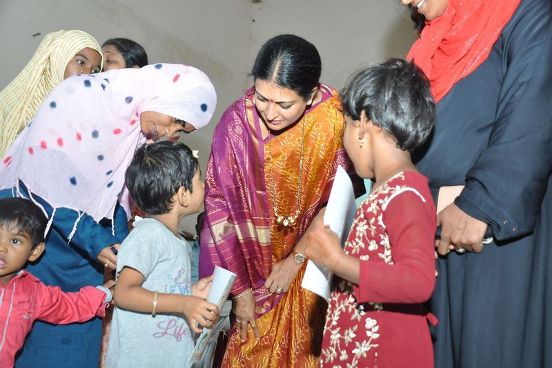 A trust representative greets mothers and children at the programme.
