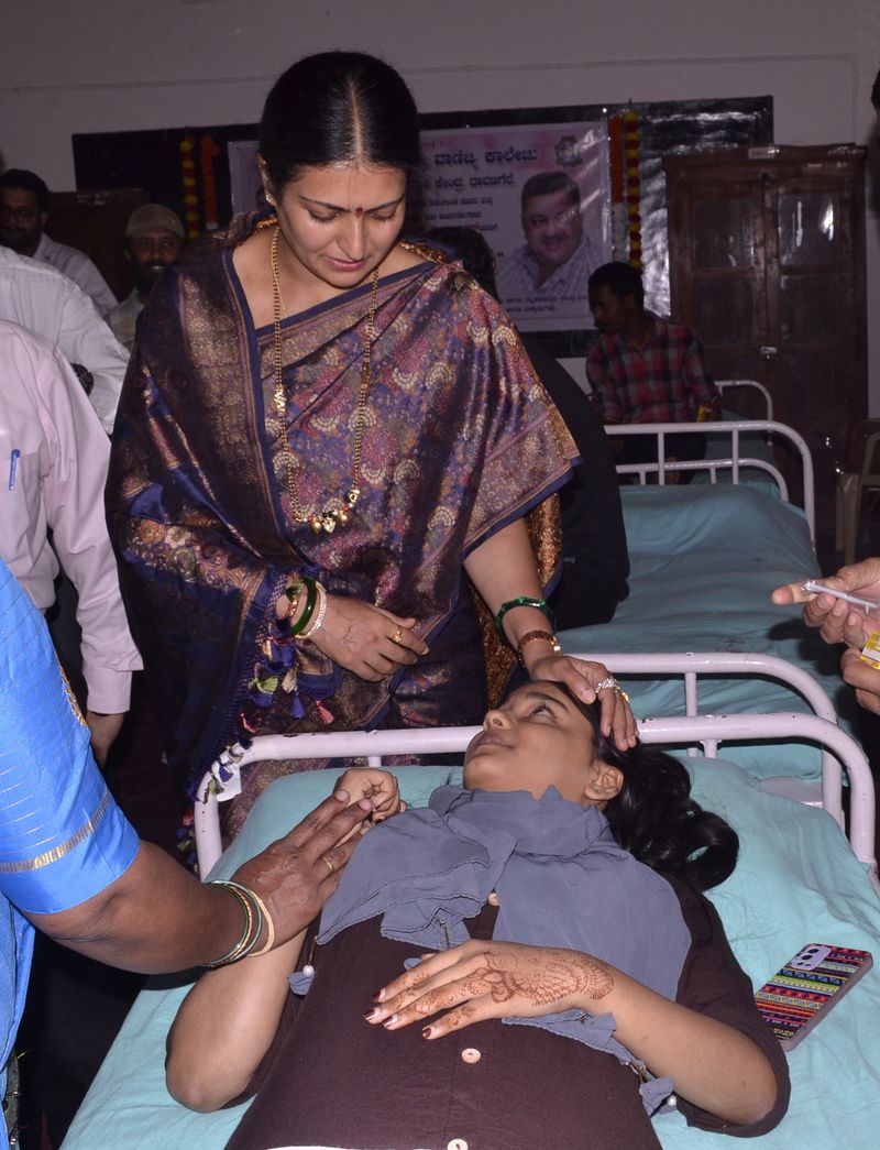 A trust representative comforts a young woman on a donation bed.
