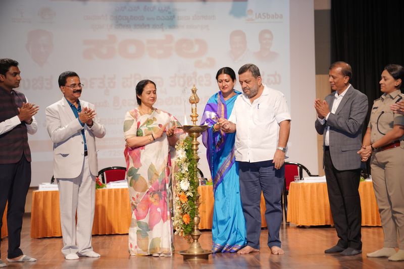 Dignitaries light a lamp on stage to launch the Sankalpa civil-services programme.