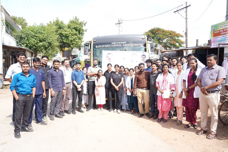 The Health-on-Wheels team of doctors, medical students and staff in front of the Bapuji Educational Association bus.