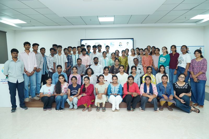 A large group of trainees and facilitators pose together for a photo after a first aid training session.