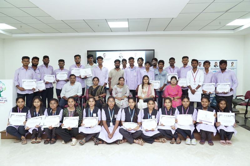 Trainees and staff pose together holding completion certificates after a first aid and basic life support training programme.