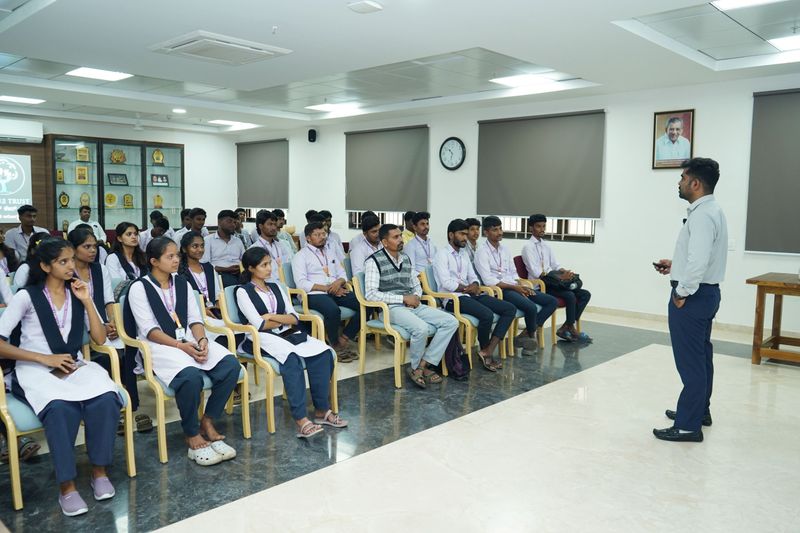 Trainer addressing a seated group of young men and women during a first aid and life support training session.