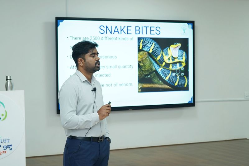 Trainer presenting a slide on snake bite first aid during an SS Care Trust basic life support session.