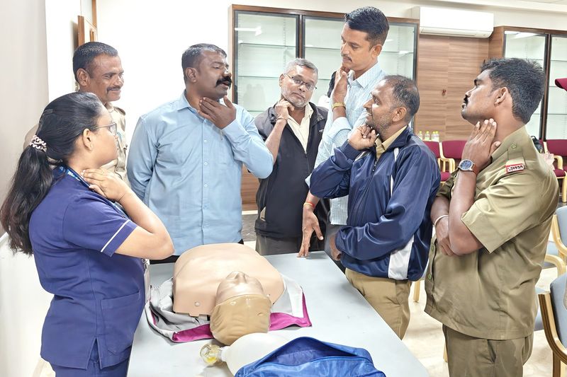 Group of participants practising the hand position used to respond to a choking emergency during first aid training.