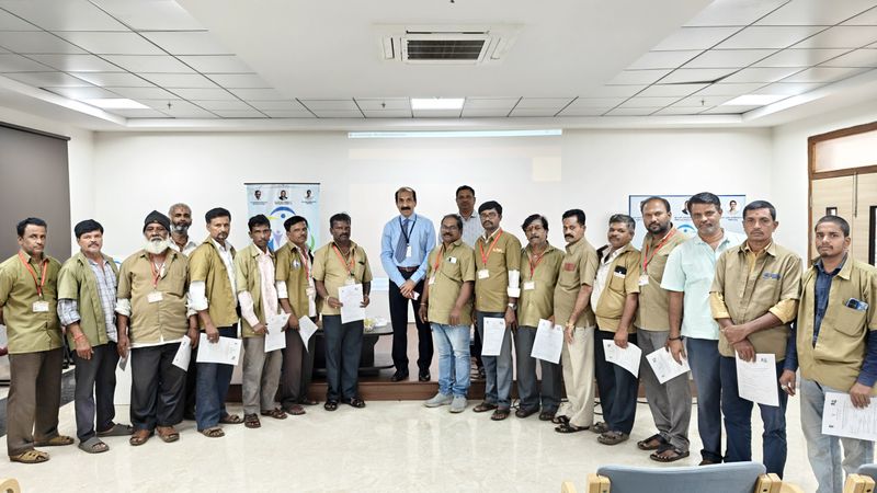 A line of uniformed men pose with certificates alongside two facilitators after completing a first aid and basic life support training.