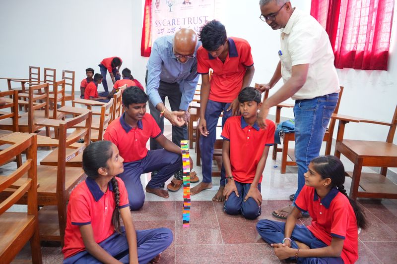 Students and mentors build a tall block tower together as a team-building activity at a Kaushalya programme.