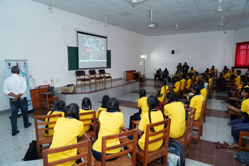 Students in yellow uniforms watch a video presentation during a Kaushalya classroom session.
