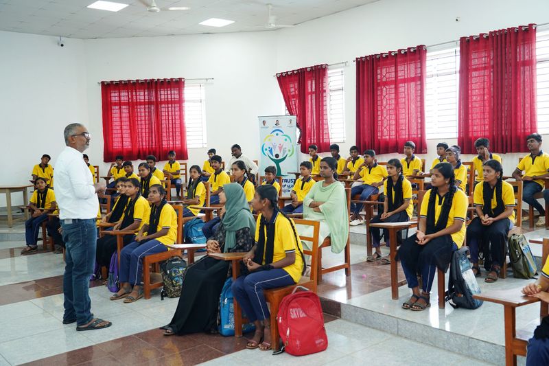 A facilitator addresses a seated group of school students during a Kaushalya awareness session.