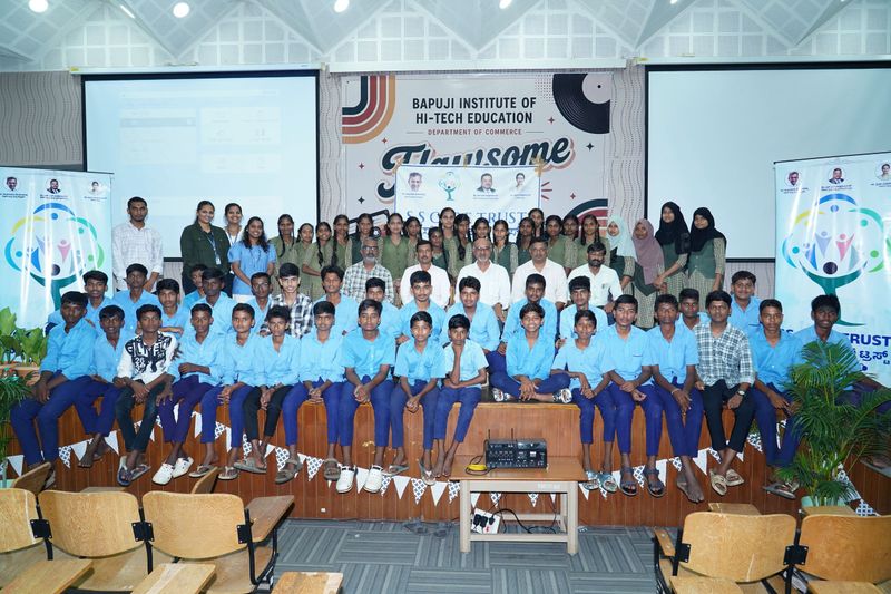 Large group photo of students, teachers and S S Care Trust representatives on stage at Bapuji Institute of Hi-Tech Education.