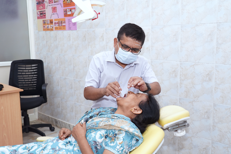 A dentist examines a woman's teeth during a community dental check-up camp.