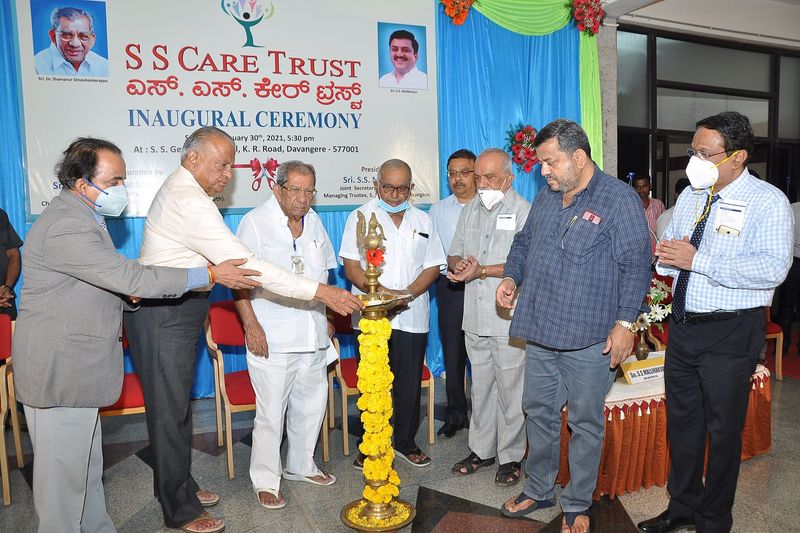 Officials lighting a traditional brass lamp on stage at SS Care Trust's haemodialysis centre inaugural ceremony.